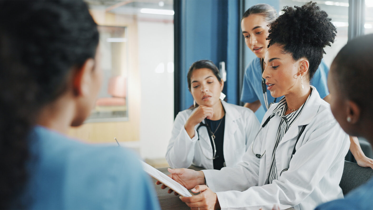 Doctors, nurse and women on clipboard in meeting, collaboration or teamwork for hospital planning