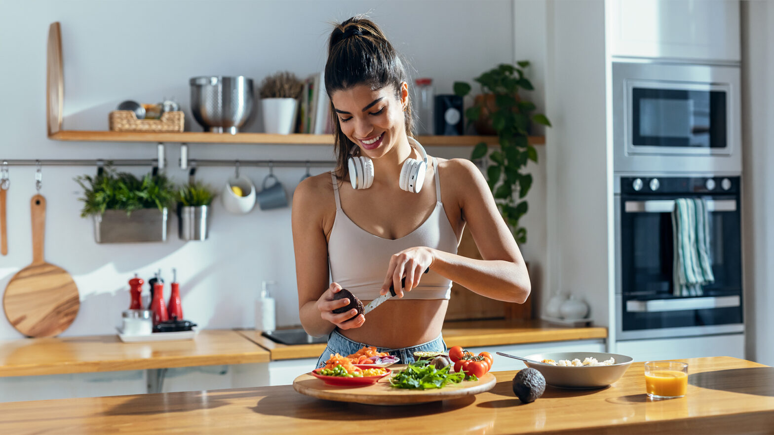 Fintess woman making a healthy poke bowl in the kitchen at home.